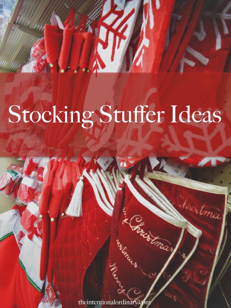 Different red-colored stockings hanging on a pegwall, with a banner over the image that says in white lettering, "Stocking Stuffer Ideas."